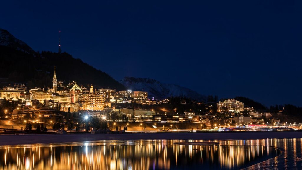 St. Moritz im Engadin. Ein Blick vom Silvaplanersee auf das beleuchtete St. Moritz bei Nacht.
