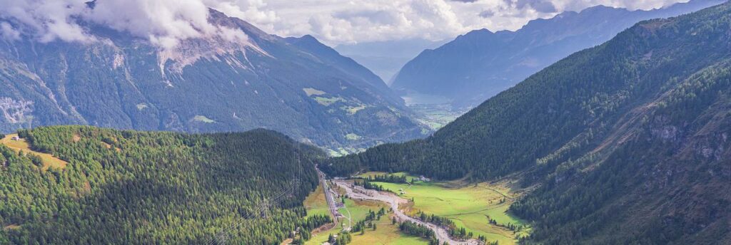 Panorama Ansicht aus der Vogelperspektive von Graubünden in der Schweiz. Ein Tal umringt von drei Bergketten im Sommer bei Sonnenschein.