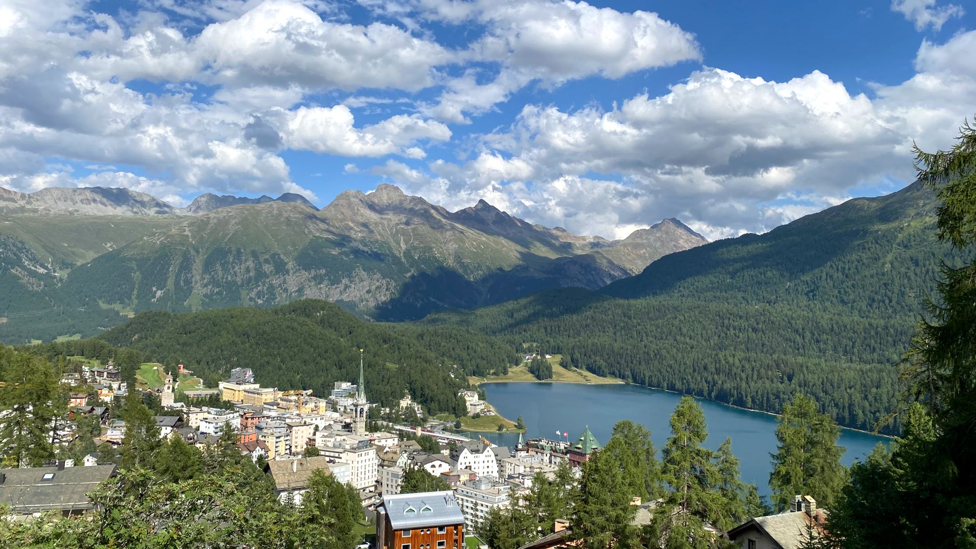 Ferien in der Schweiz | Urlaub St. Moritz im Sommer, Bedeckter Himmel, grüne Bäume und ein Dorf direkt am See.