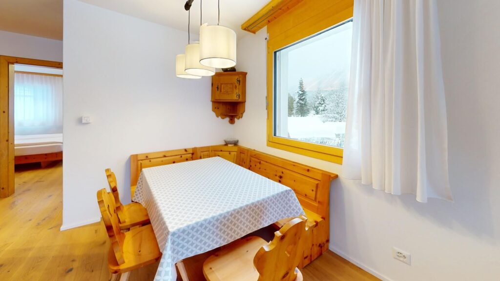 Esstisch mit Stühlen und Sitzecke aus Holz von der Seite